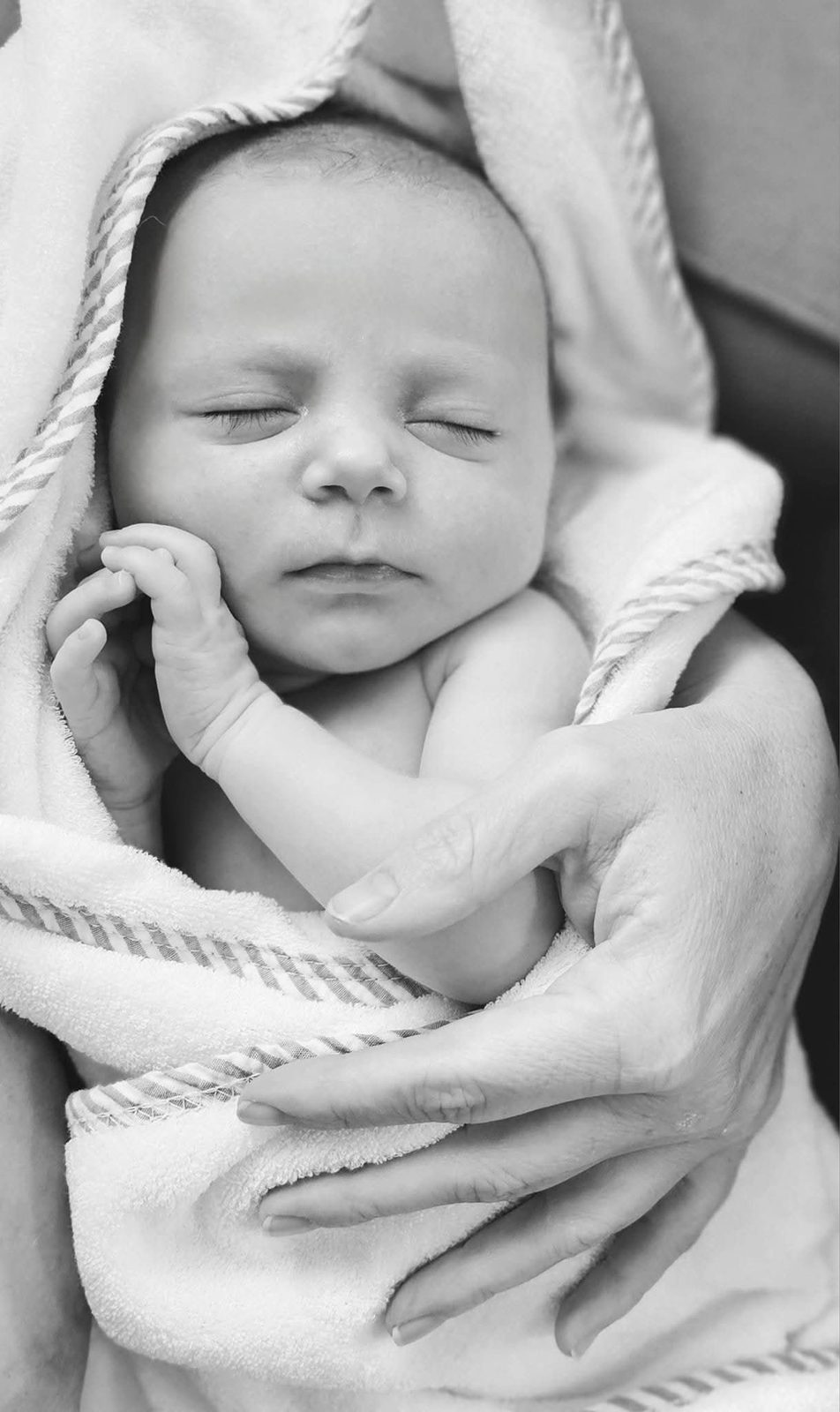 Sleeping newborn swaddled in a towel, black and white