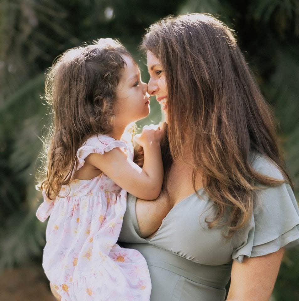 Mom and daughter touching noses in soft light