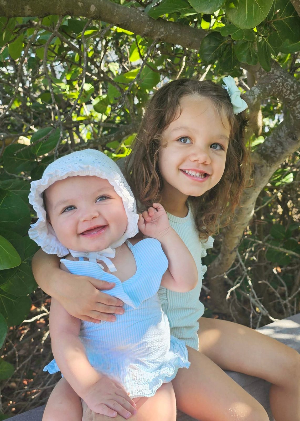Sisters smiling under a sea grape tree
