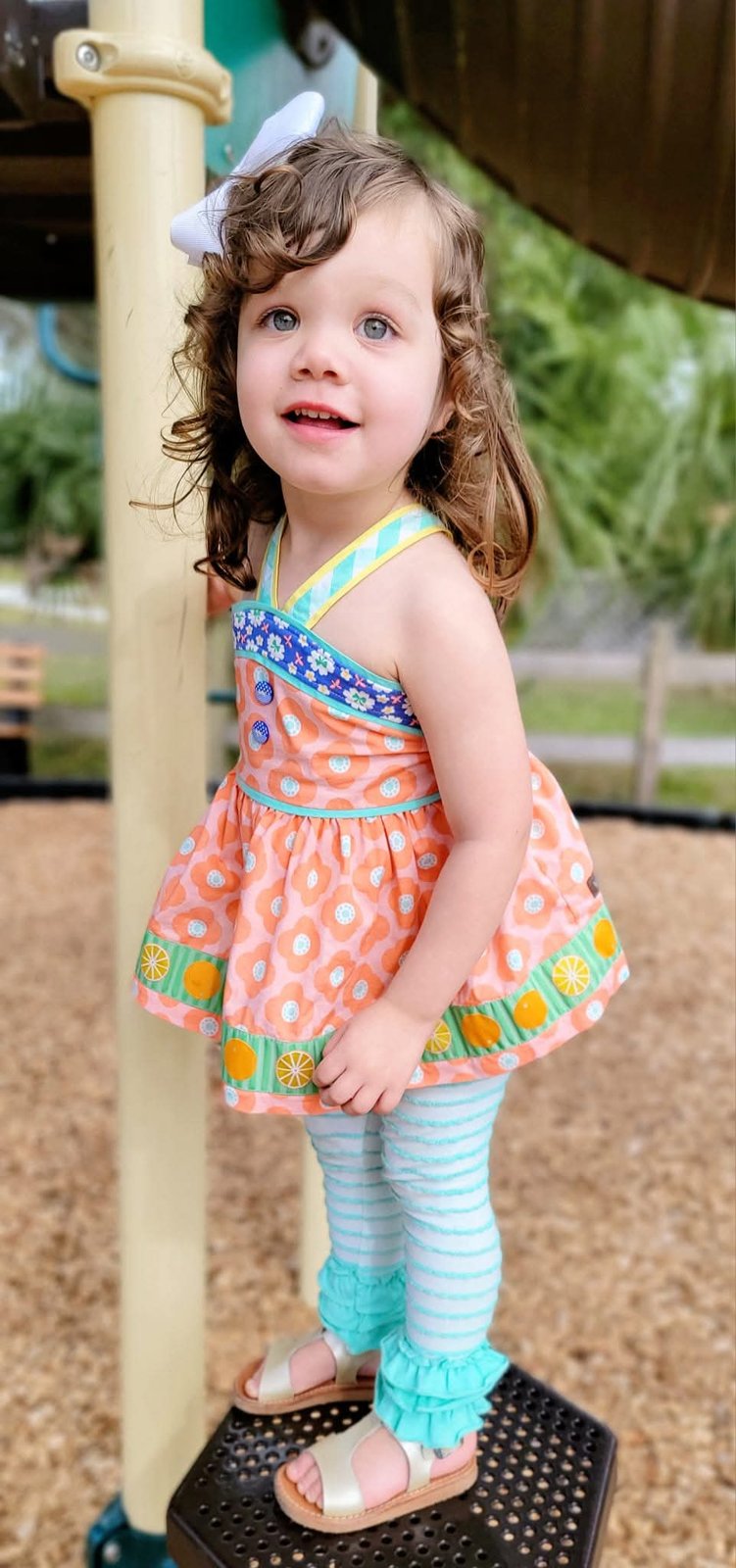 Toddler in a bright patterned outfit at the playground
