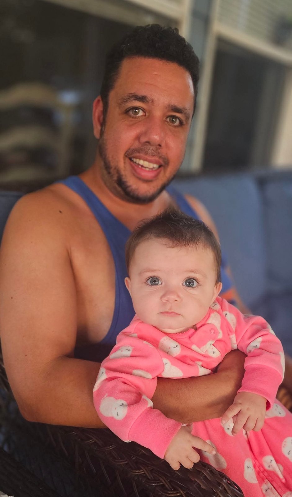 Dad holding his baby daughter in pink pajamas