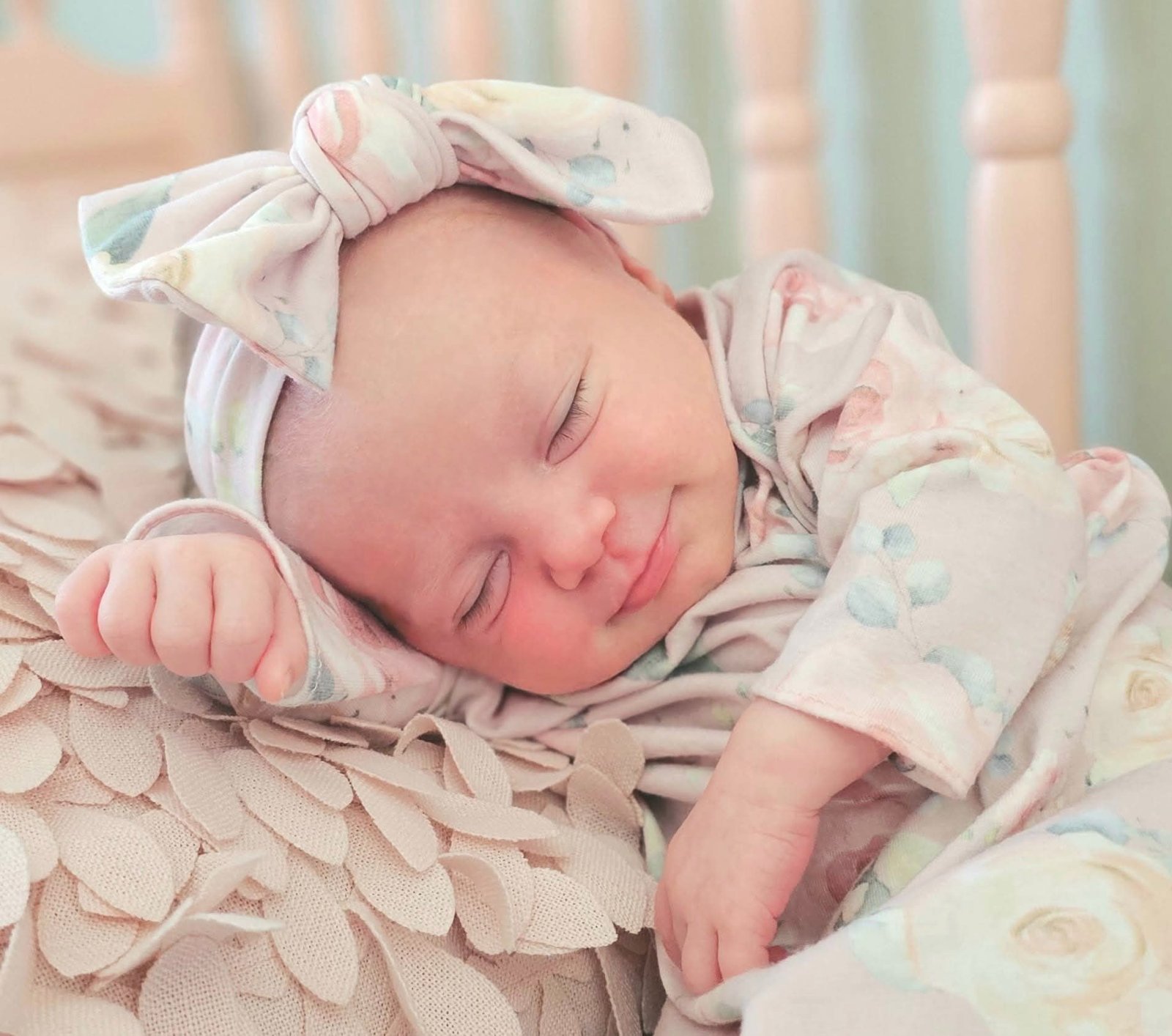 Newborn sleeping and smiling in a floral headband