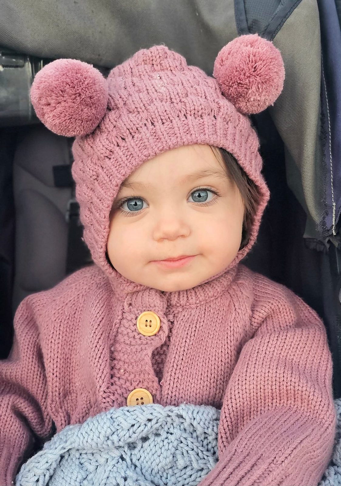 Baby in a pink pom-pom knit hat