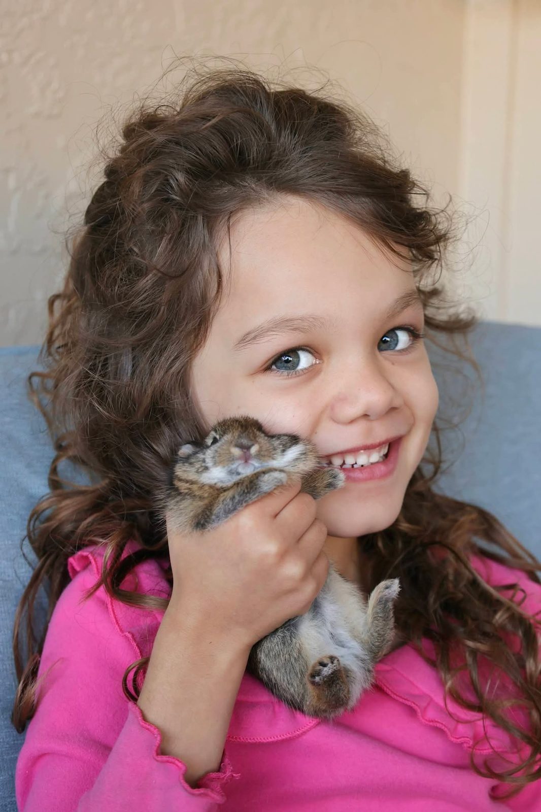 Curly-haired girl cuddling a bunny