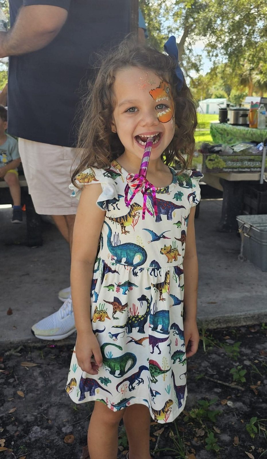 Girl in a dinosaur dress with face paint